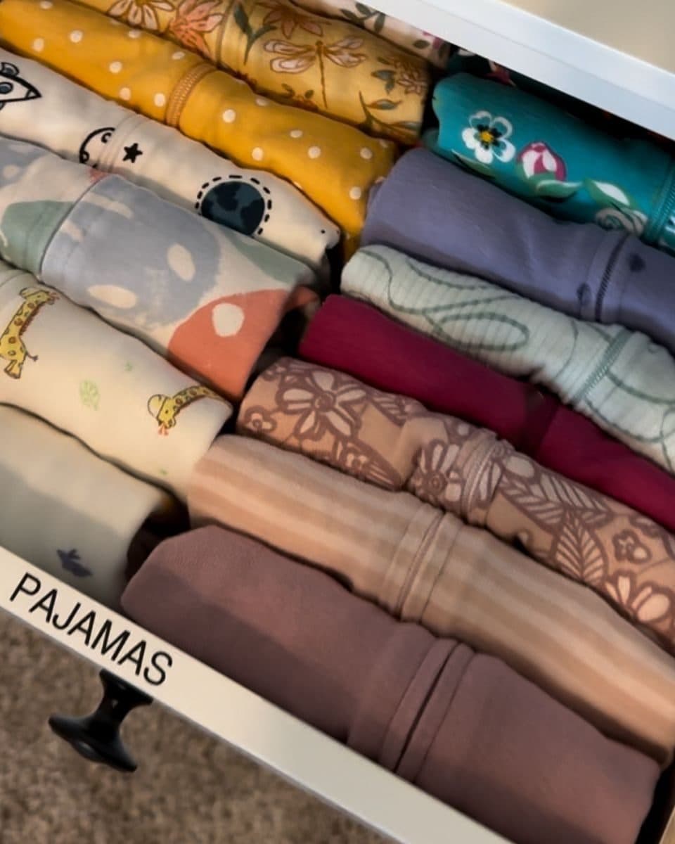A white drawer labeled PAJAMAS with small folded pajamas standing upright in rows, every print visible.